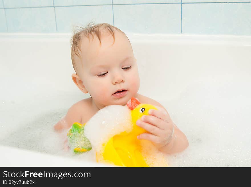 Cute adorable baby play with toy sitting in foam bath. Cute adorable baby play with toy sitting in foam bath