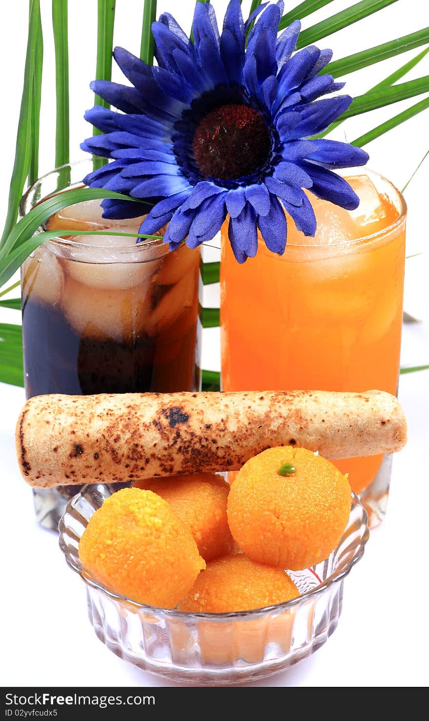 Orange and cola drink glasses with indian sweets isolated on white background. Orange and cola drink glasses with indian sweets isolated on white background.