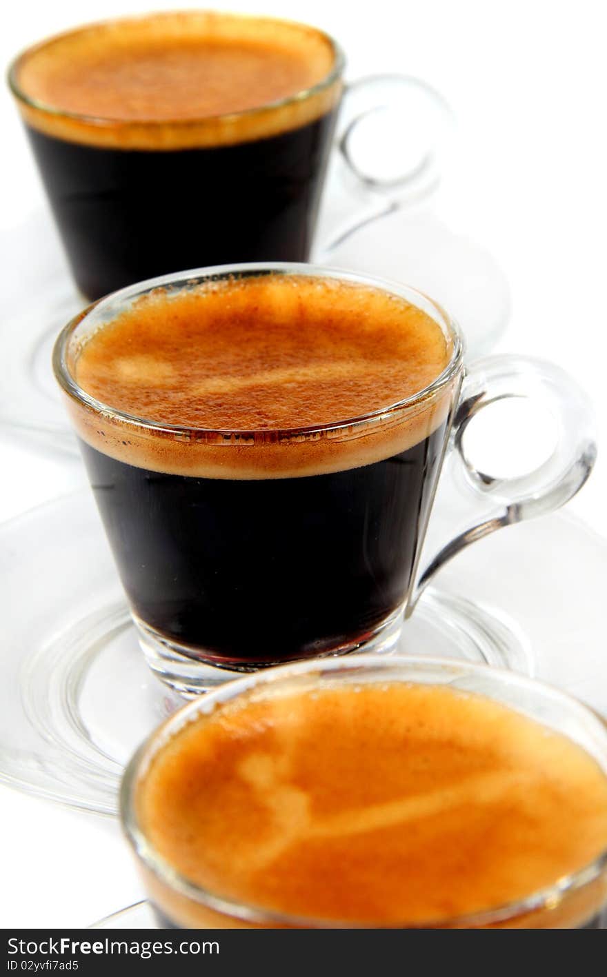 Espresso in the  transparent cups on the white background. Espresso in the  transparent cups on the white background