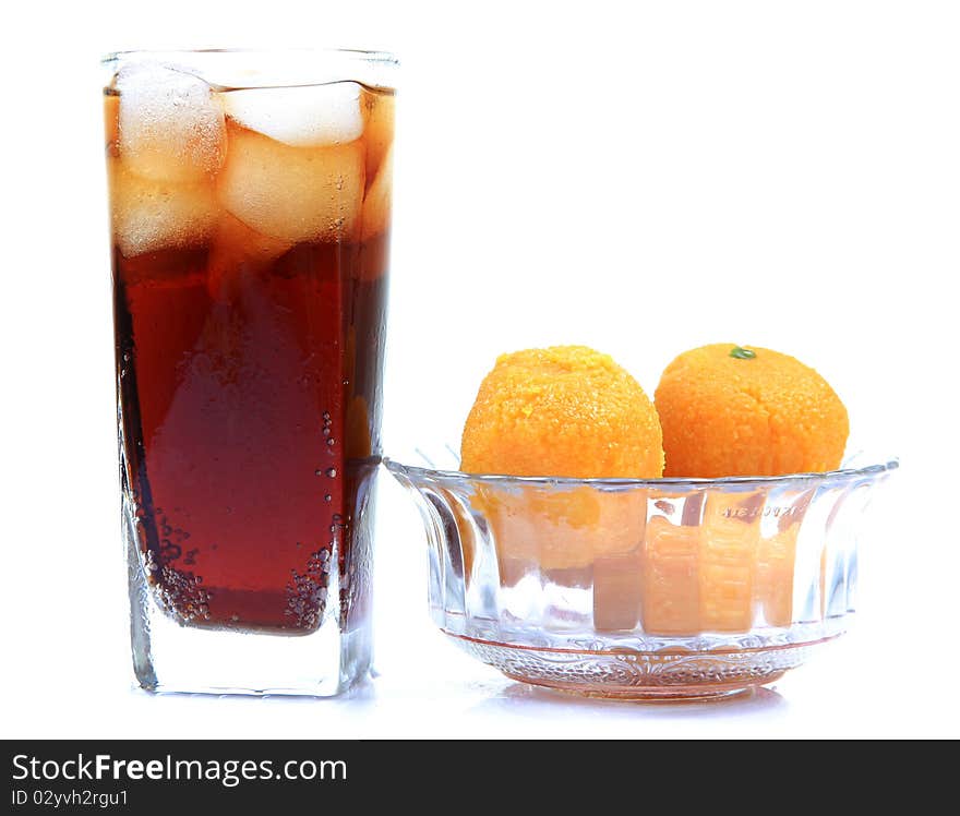 Orange and cola drink glasses with indian sweets isolated on white background. Orange and cola drink glasses with indian sweets isolated on white background.