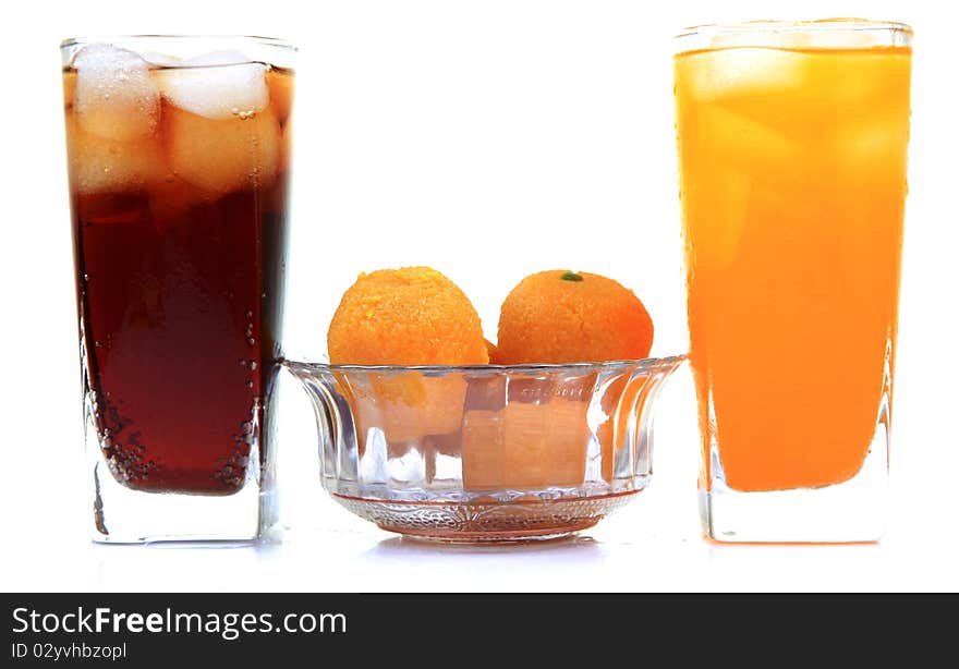 Orange and cola drink glasses with sweets isolated on white background. Orange and cola drink glasses with sweets isolated on white background.