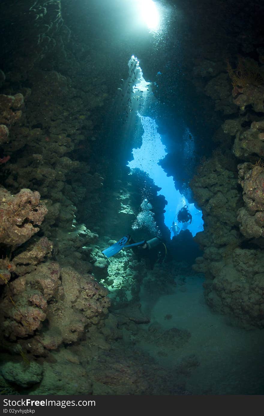 Scuba divers inside an underwater cave.