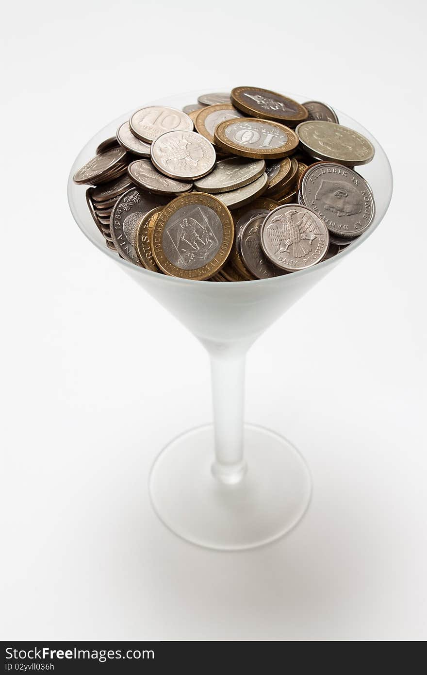 Foreign coins lie in a glass