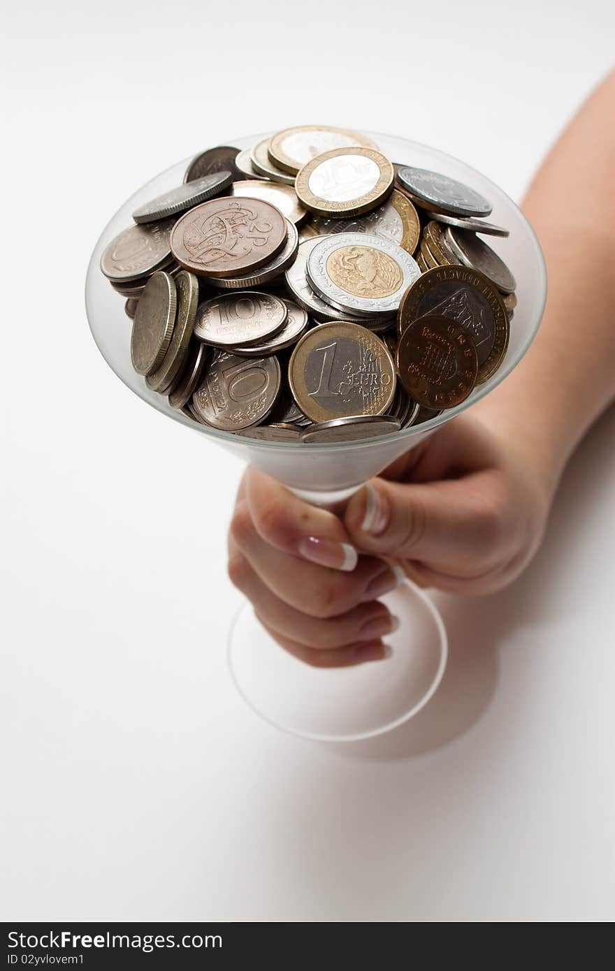 The female hand holds a glass full of money. The female hand holds a glass full of money