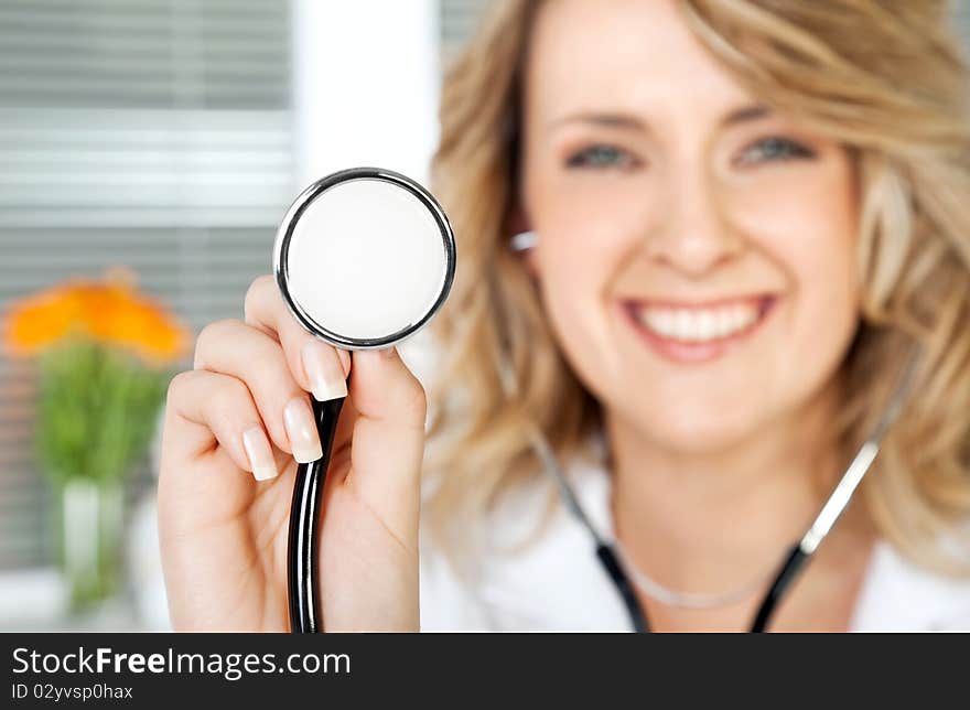 Close-up of stethoscope, being held by smiling female doctor, focus on instrument. Close-up of stethoscope, being held by smiling female doctor, focus on instrument