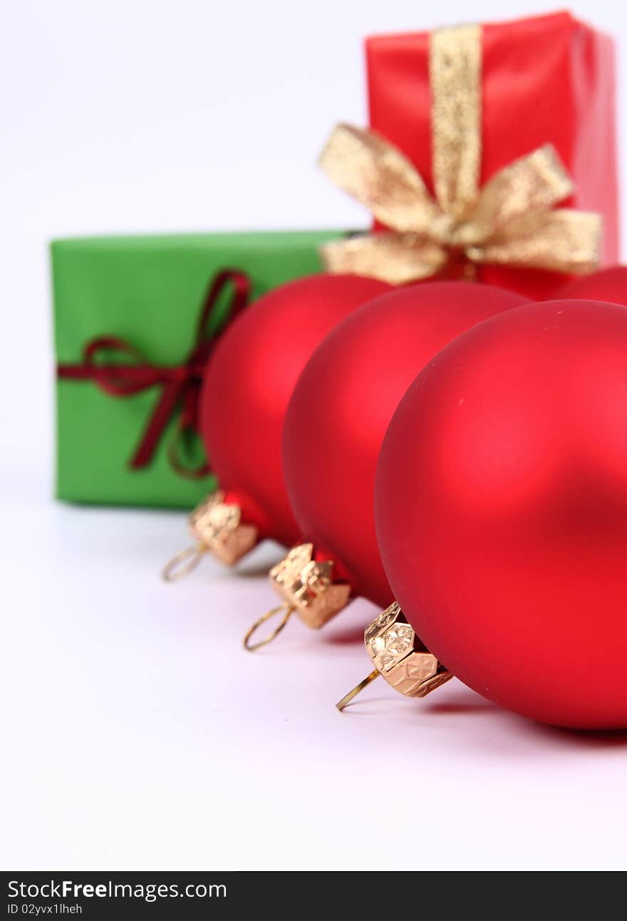 Red matt christmas balls and gifts in green and red wrapping on white background, with space for your text. Red matt christmas balls and gifts in green and red wrapping on white background, with space for your text