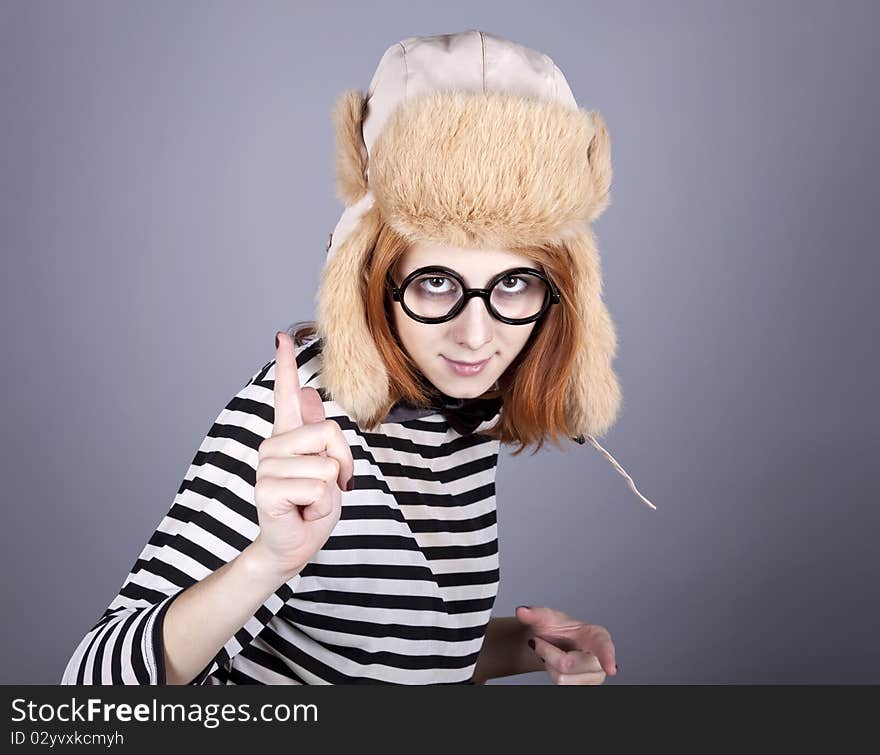 Funny girl in winter cap and glasses. Studio shot.