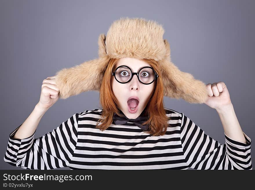 Funny girl in winter cap and glasses. Studio shot.