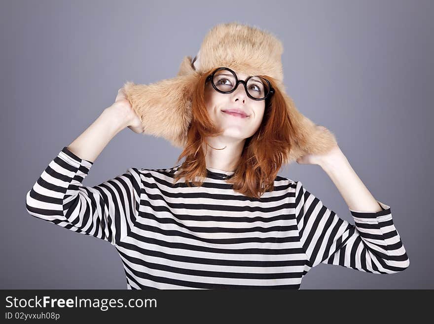 Funny girl in winter cap and glasses. Studio shot.