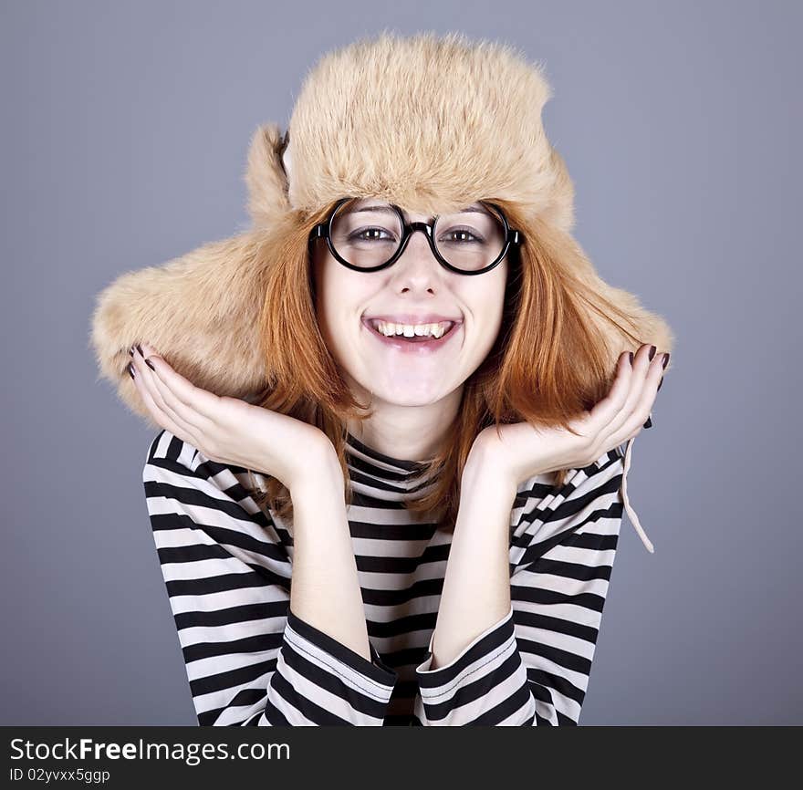 Funny girl in winter cap and glasses. Studio shot.