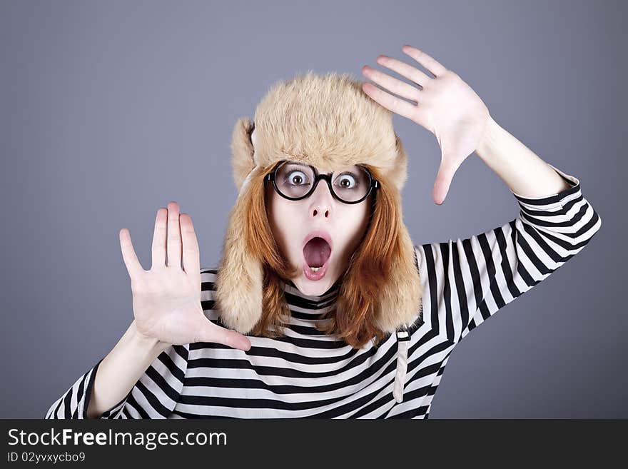 Funny girl in winter cap and glasses. Studio shot.