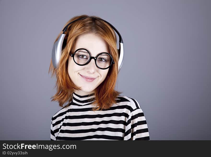 Funny girl with headphone and glasses. Studio shot.