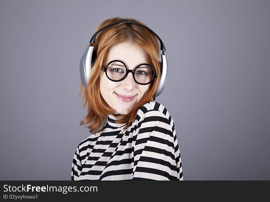 Funny girl with headphone and glasses. Studio shot.