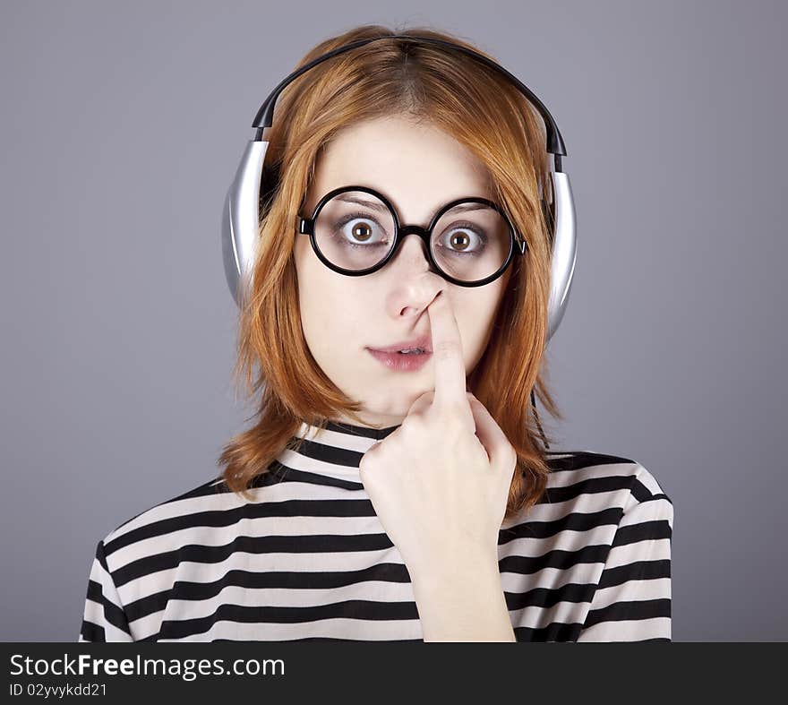 Funny girl with headphone and glasses. Studio shot.