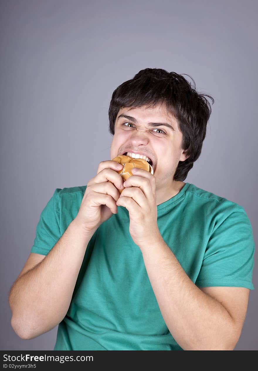 Cute boy eating hamburger. Studio shot.