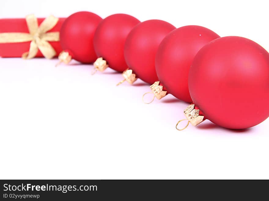 Red matt christmas balls and a gift in red wrapping on white background, with space for your text. Red matt christmas balls and a gift in red wrapping on white background, with space for your text