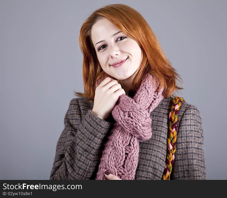 Portrait of beautiful red-haired girl in coat. Studio shot.