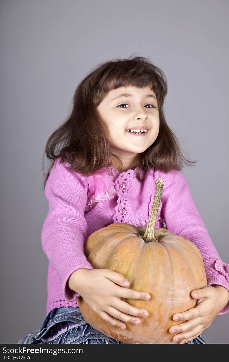 Smiling little girl with pumpkin.