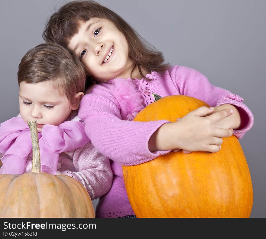 Two little sisters with pumpkin