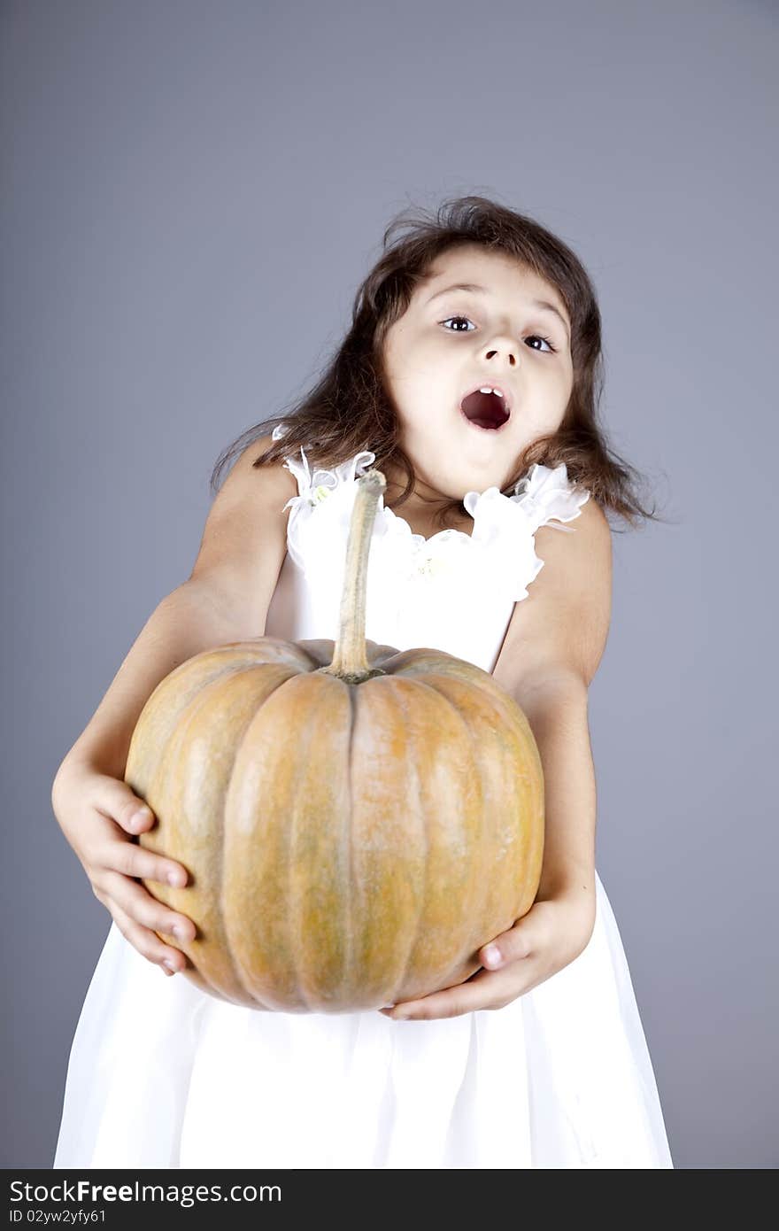 Funny Little Girl In Dress Keeping Pumpkin.