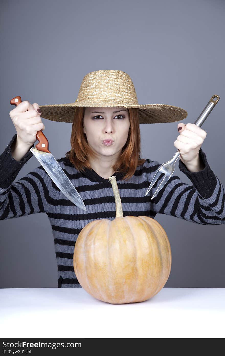 Funny girl in cap and fork with knife try to eat a pumpkin. Studio shot. Funny girl in cap and fork with knife try to eat a pumpkin. Studio shot.