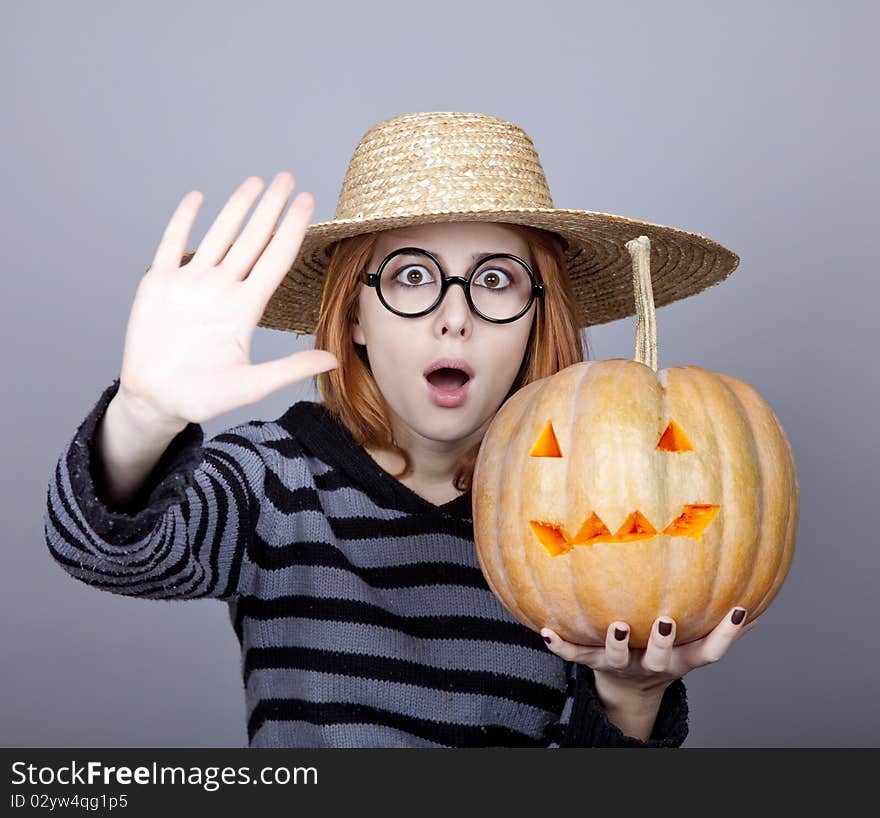 Funny girl in cap showing pumpkin.