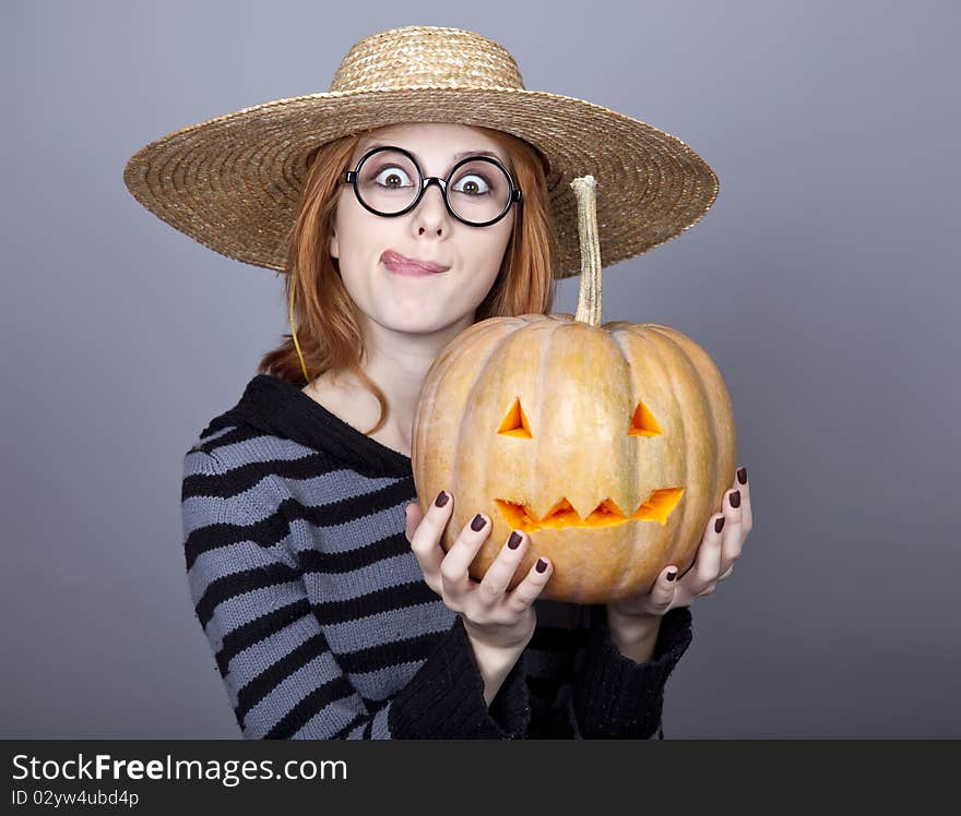 Funny girl in cap showing pumpkin.