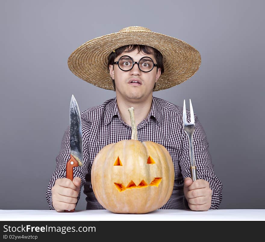 Funny men try to eat a pumpkin. Studio shot.