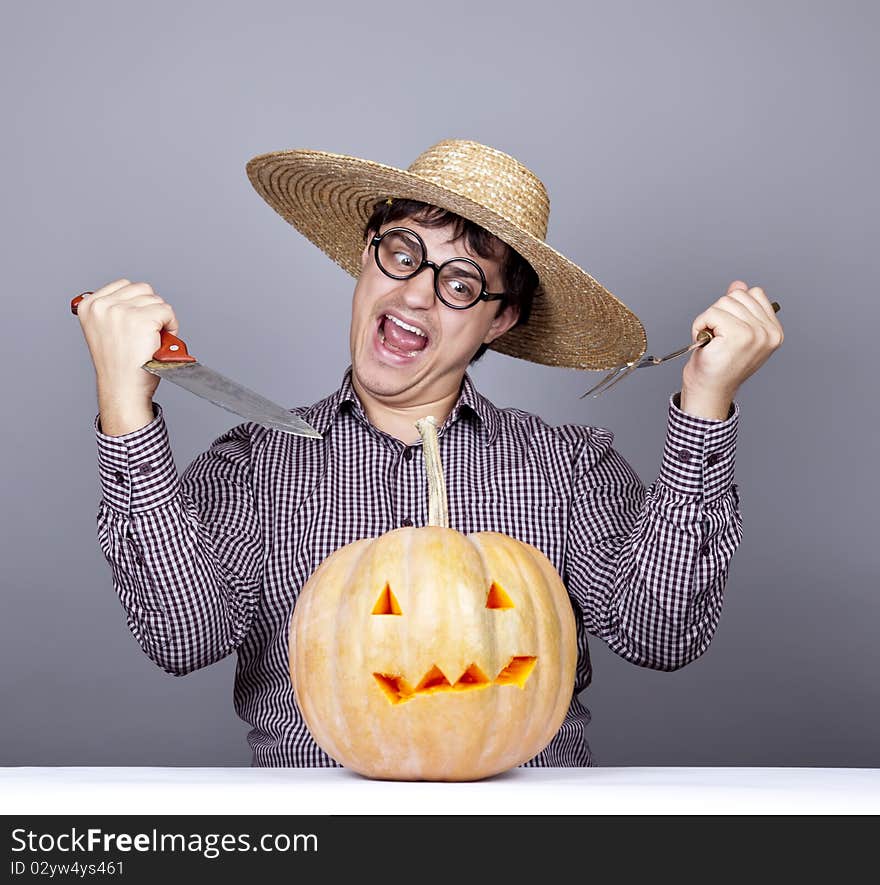 Funny men try to eat a pumpkin. Studio shot.