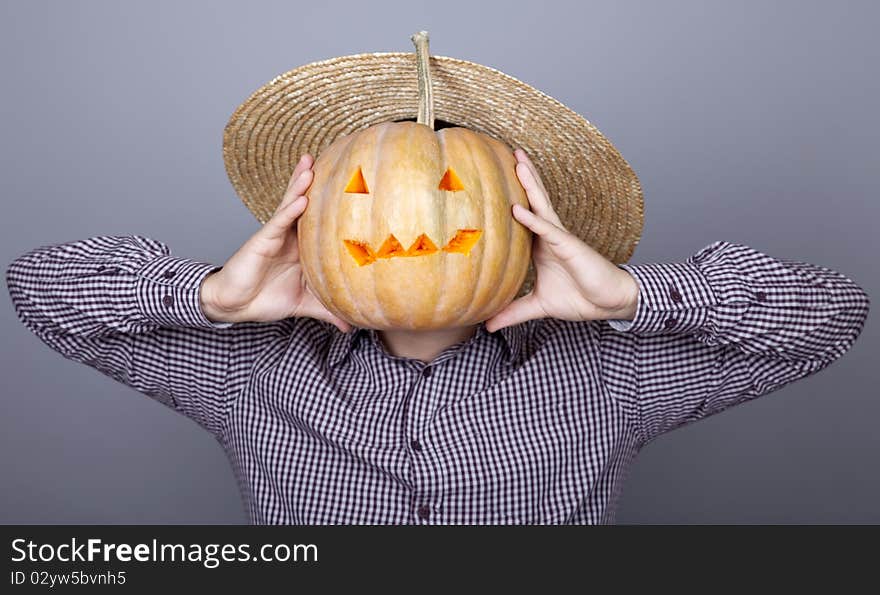 Funny men try to eat a pumpkin. Studio shot.