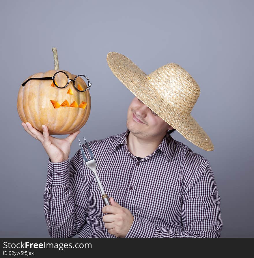 Funny men try to eat a pumpkin. Studio shot.