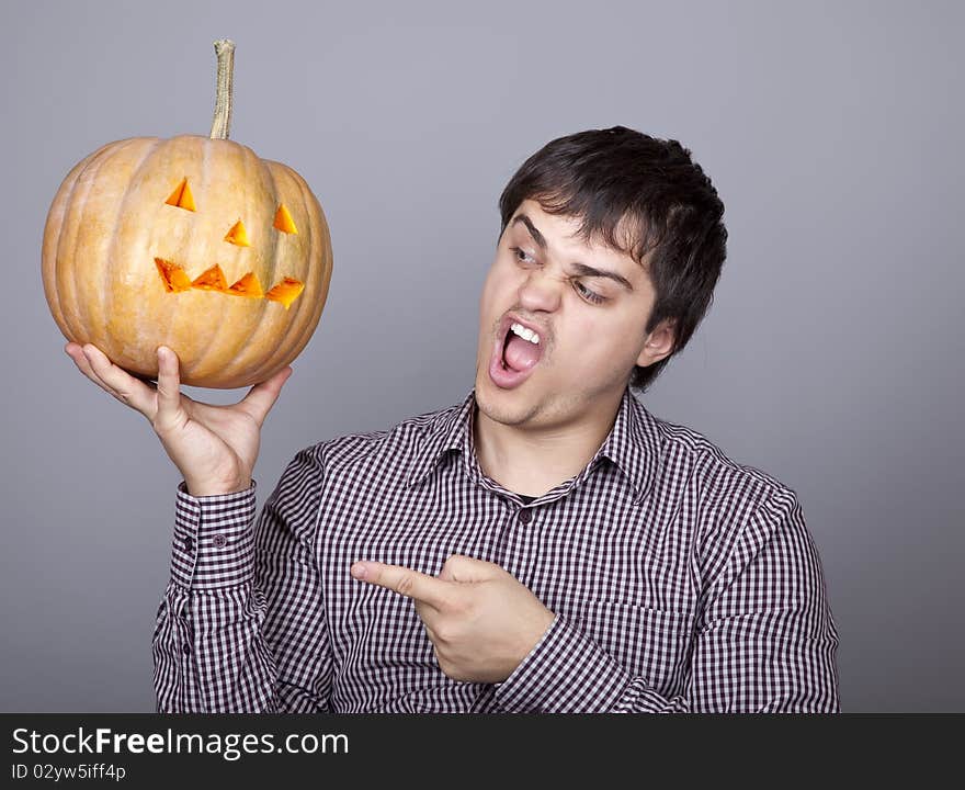 Funny men showing a pumpkin. Studio shot.