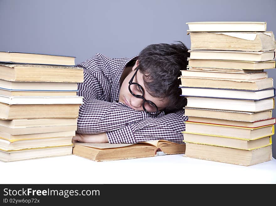 The young tired student with the books isolated. Studio shot.