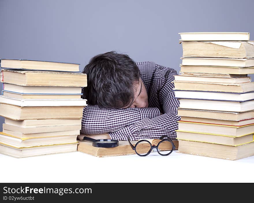 The young tired student with the books isolated. Studio shot.