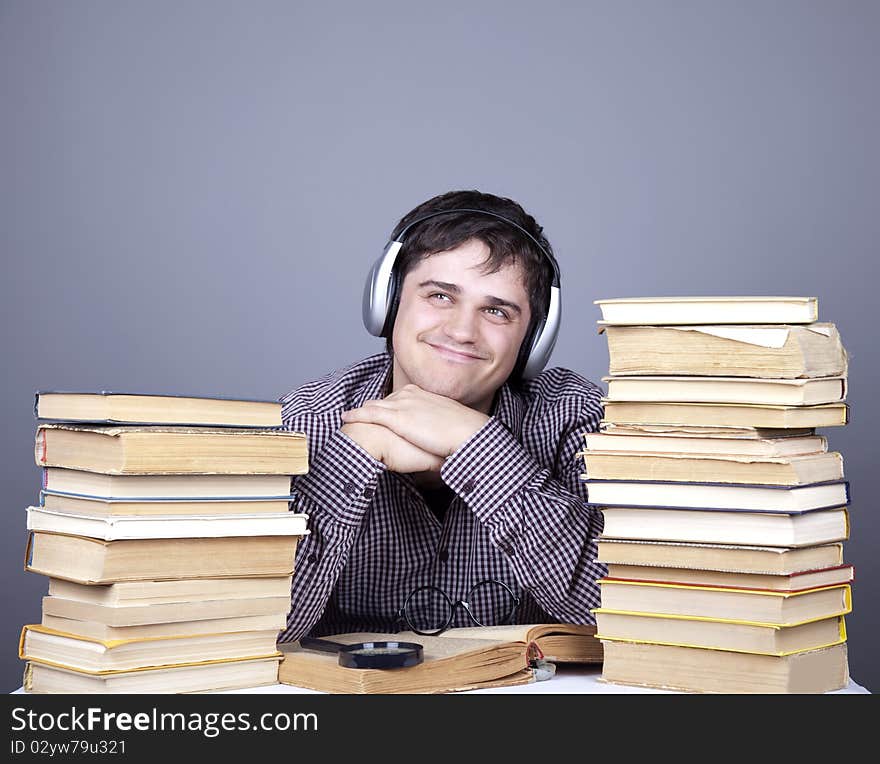 The young student with the books and headphone isolated. Studio shot.