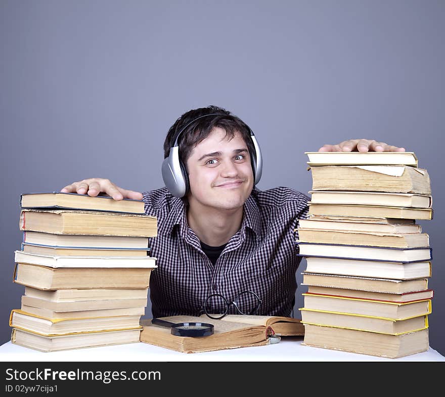 The young student with the books and headphone isolated. Studio shot.