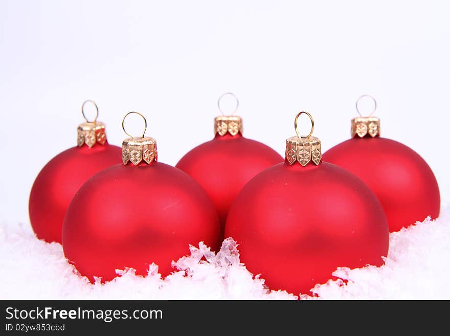 Red matt christmas balls on snow on white background, with space for your text. Red matt christmas balls on snow on white background, with space for your text