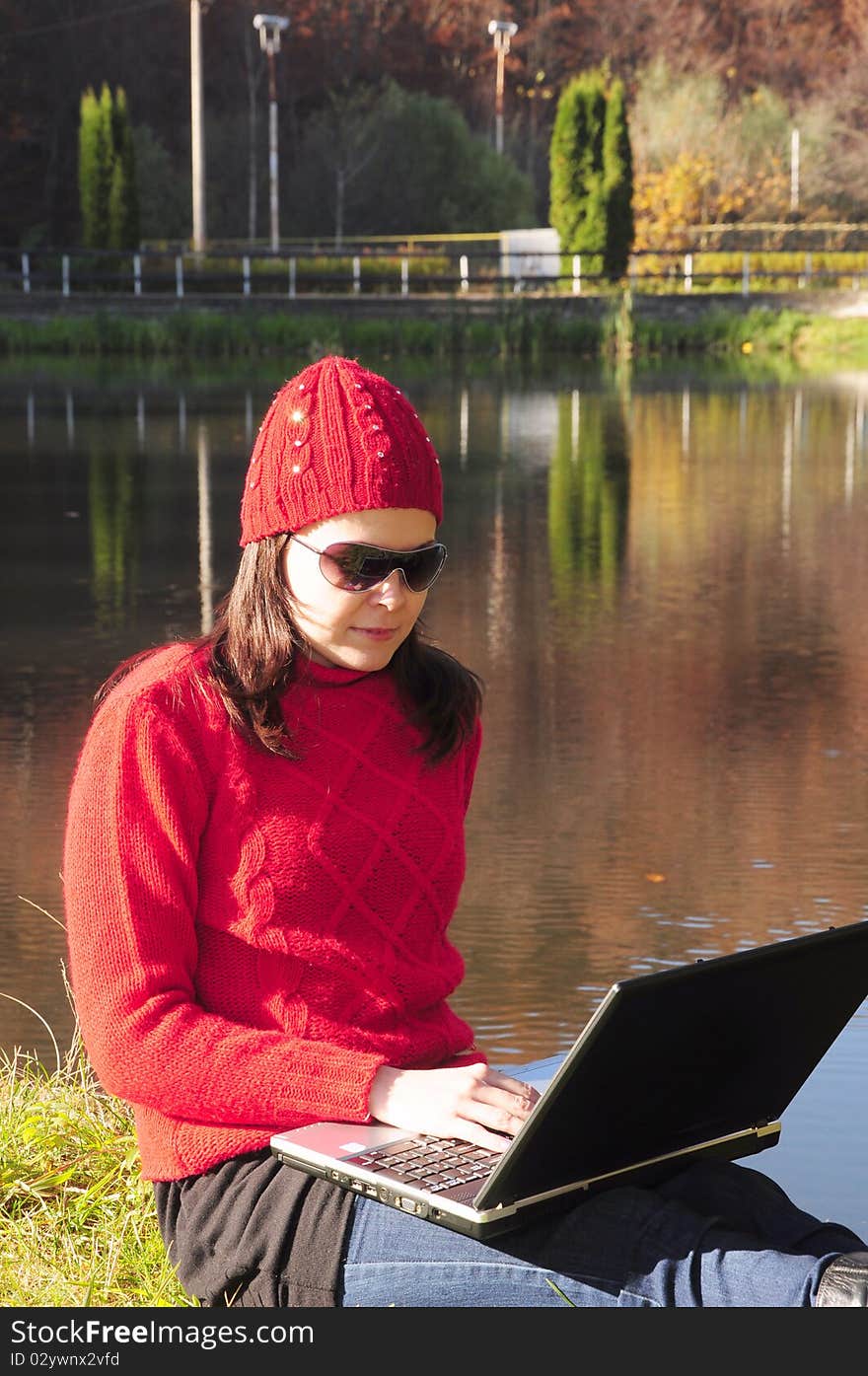 Young woman with laptop on the embankment.