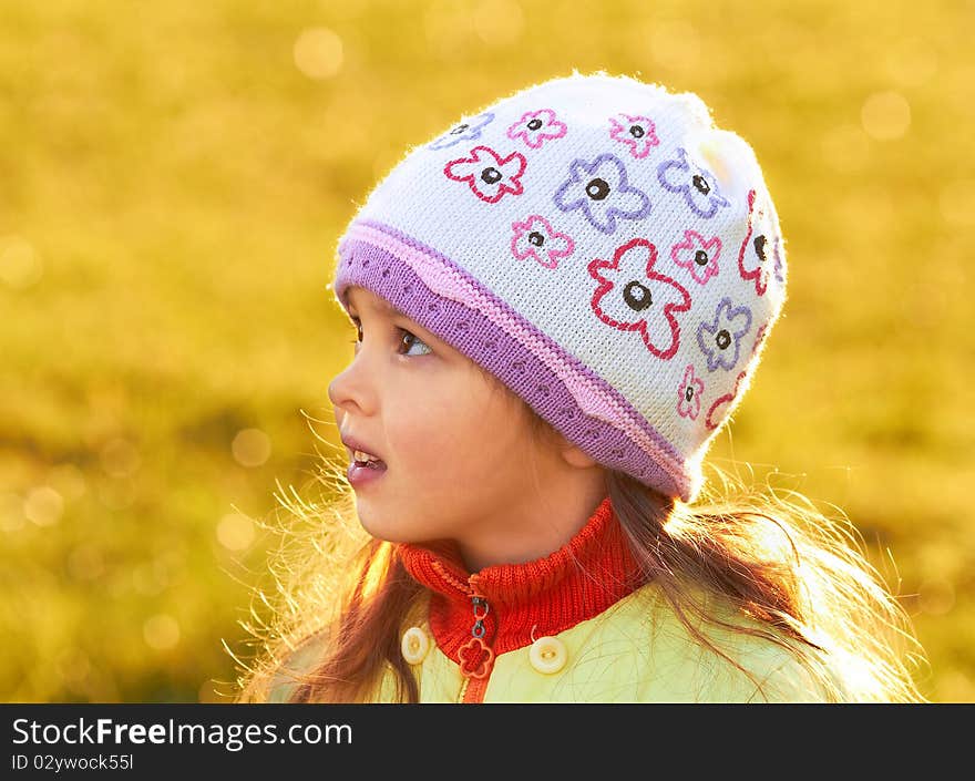 Child looks aside. Blurred yellow background. Close-up. Child looks aside. Blurred yellow background. Close-up.