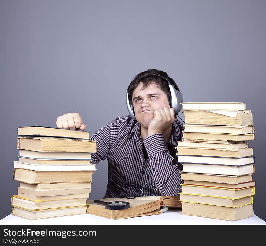 The young student with the books and headphone isolated. Studio shot.