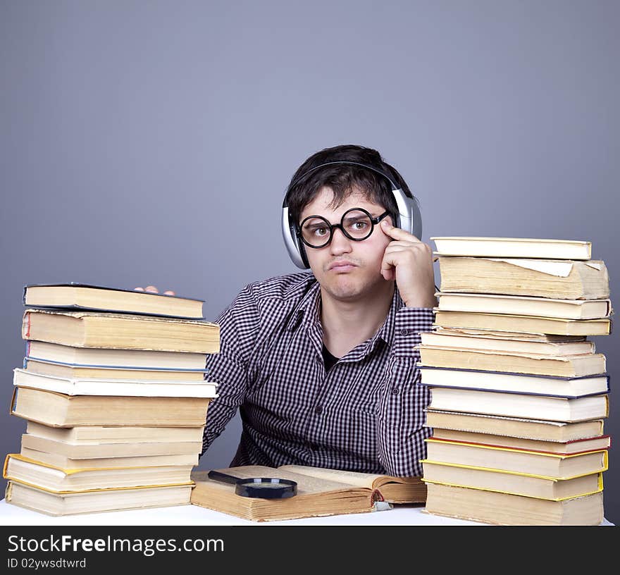 The young student with the books and headphone isolated. Studio shot.