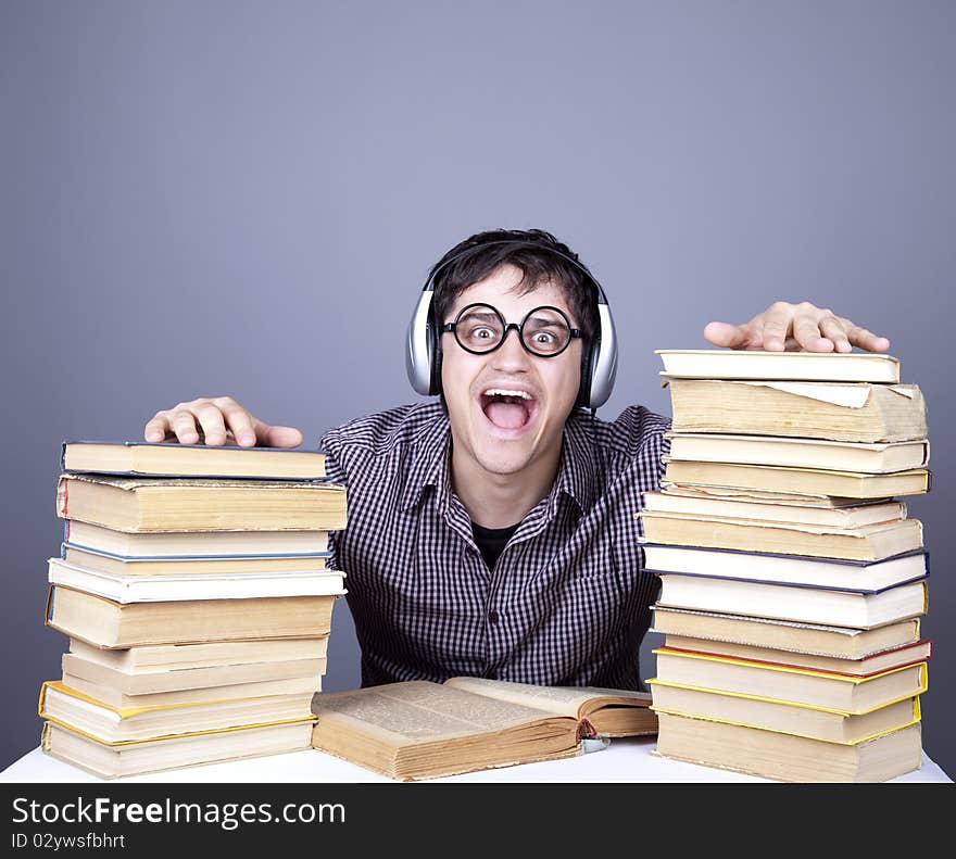 The young student with the books and headphone isolated. Studio shot.