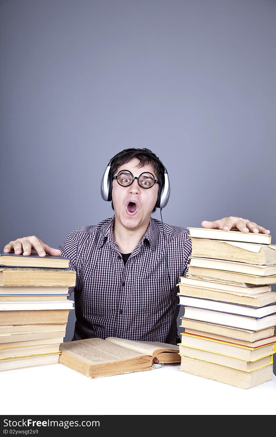 The young student with the books and headphone isolated. Studio shot.