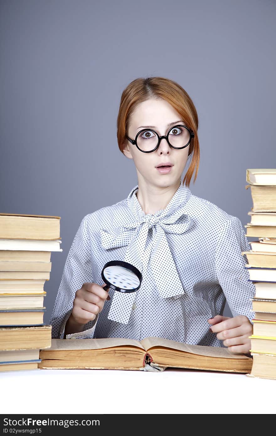 The young teacher in glasses with books. Studio shot.