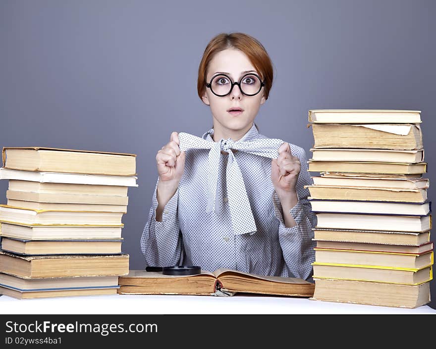 The young teacher in glasses with books. Studio shot.