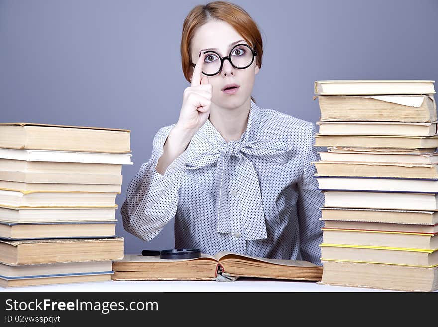 The young teacher in glasses with books. Studio shot.