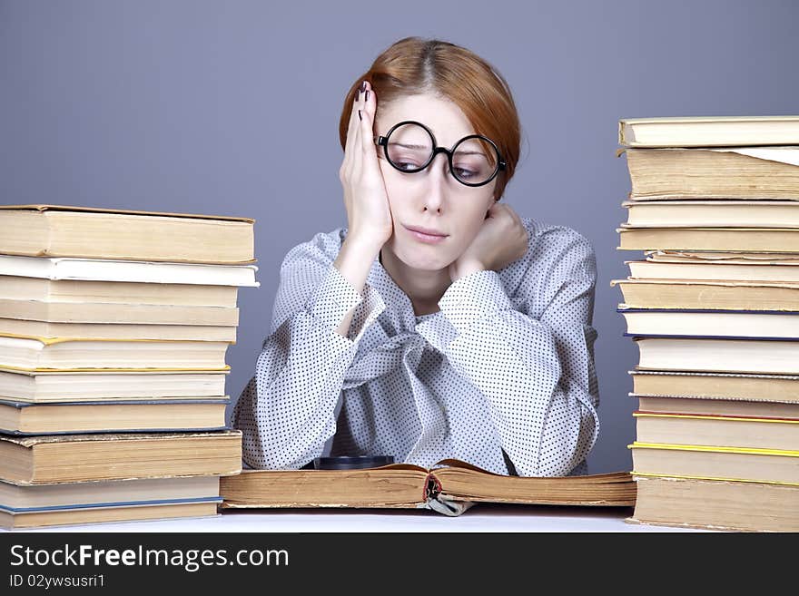 The young teacher in glasses with books. Studio shot.