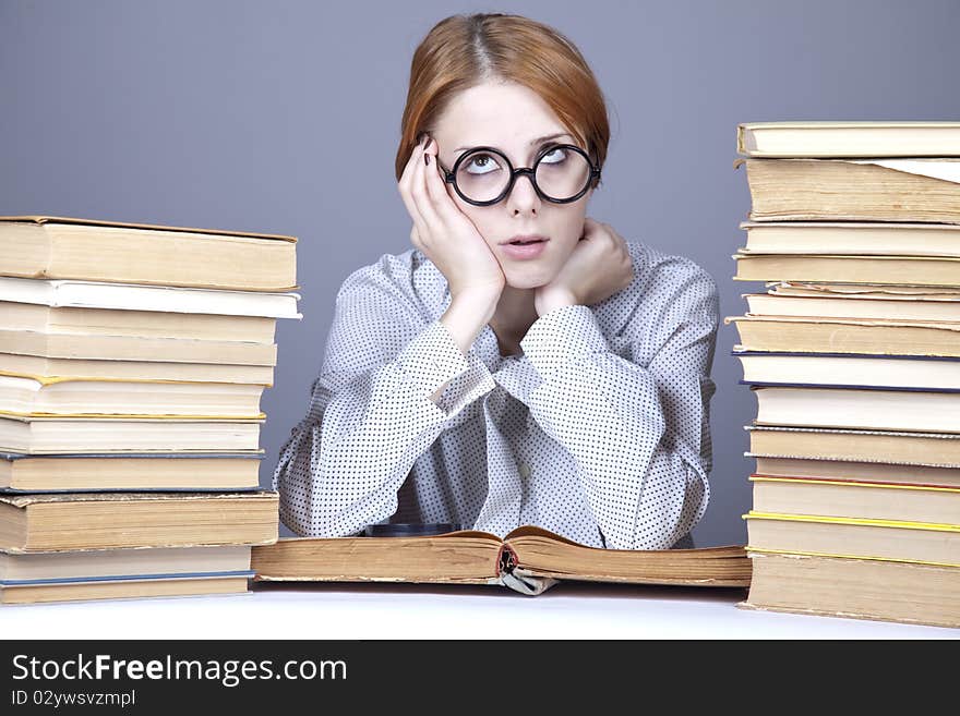 The young teacher in glasses with books. Studio shot.