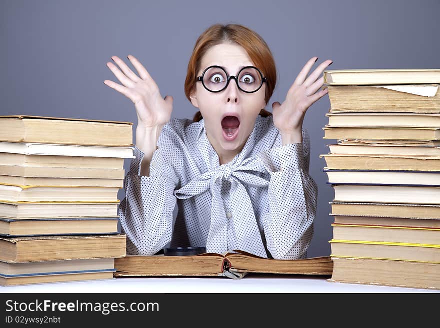 The young teacher in glasses with books. Studio shot.