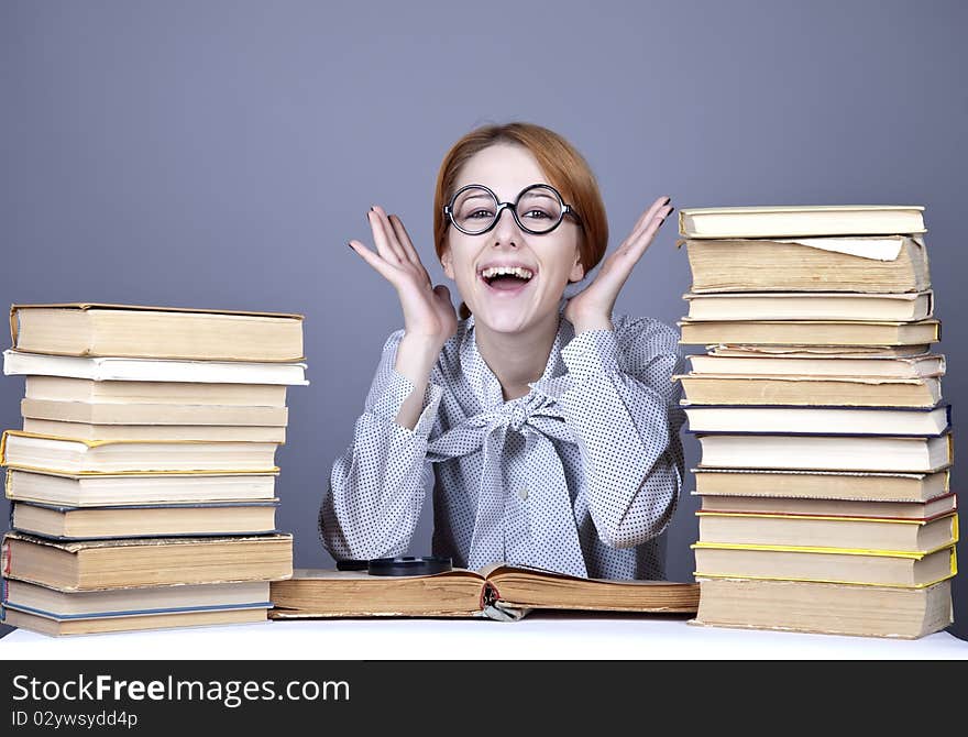 The young teacher in glasses with books. Studio shot.